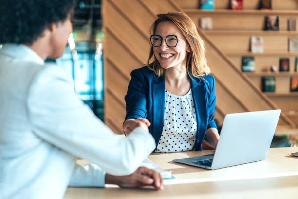 woman shaking hands with client